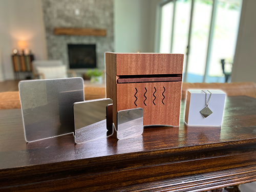 three mirrors, wooden box and a cardboard box with a necklace standing on the table